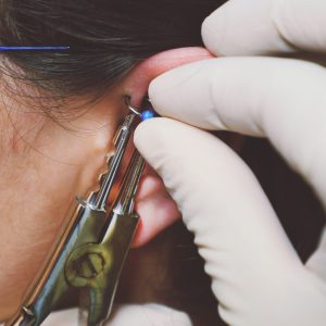 Close up detail shot of using equipment for ear piercing after using numbing cream